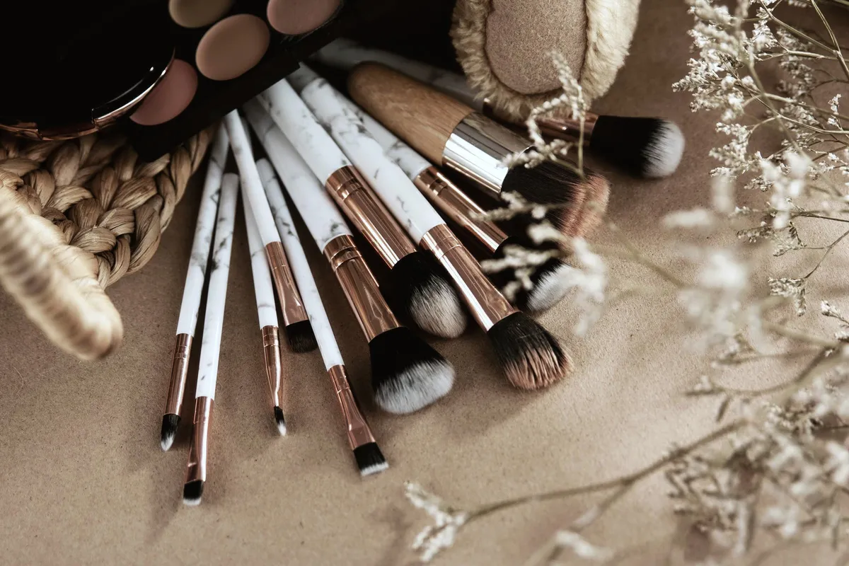 Pinceaux de maquillage et palette de teintes dans des tons beiges